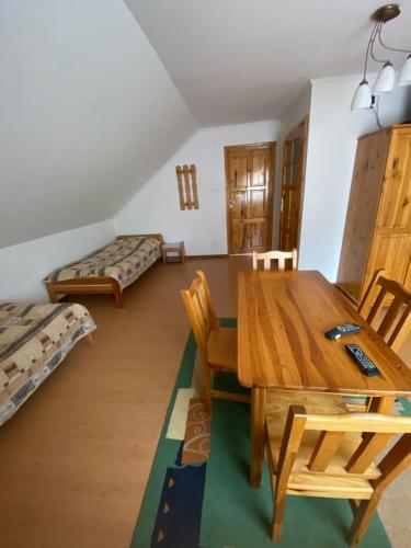 - un salon avec une table et des chaises en bois dans l'établissement Agroturystyka Marysieńka, à Rymanów-Zdrój