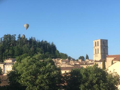 a hot air balloon flying over a city at CHAMBRE CENTRE VILLE Coté soleil in Forcalquier