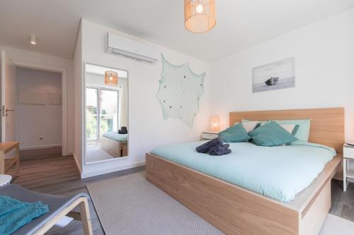 a bedroom with a bed and a table and a mirror at SeaSimbra Apartment in Sesimbra