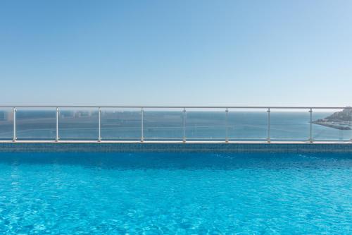 a large pool of blue water next to a bridge at SeaSimbra Apartment in Sesimbra