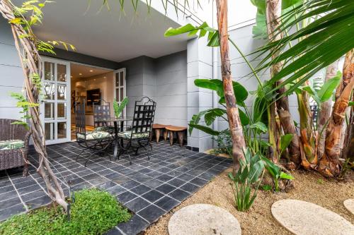 a patio with a table and chairs and trees at Romney Park Luxury Apartments by The Stay Collection in Cape Town