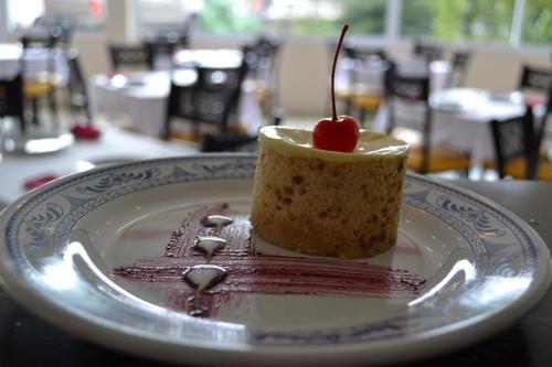 a piece of cake on a plate with a cherry on it at Hotel Casablanca Xicotepec in Xicotepec de Juárez