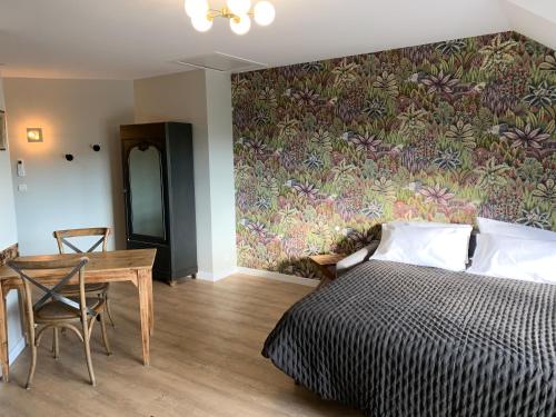 um quarto com uma cama, uma mesa e um mural de parede em L'Orée de la Chambotte em Chindrieux