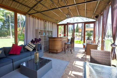 a living room with a blue couch and a bar at S'Hort de Son Caulelles - Adults Only in Marratxí 