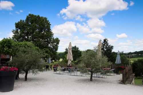a group of tables with umbrellas and chairs at Auberge des 7 Tours in Martel