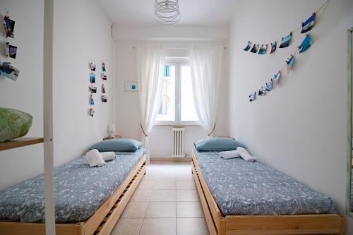 2 camas individuales en una habitación con ventana en La casa di Polignano- locazione turistica, en Polignano a Mare