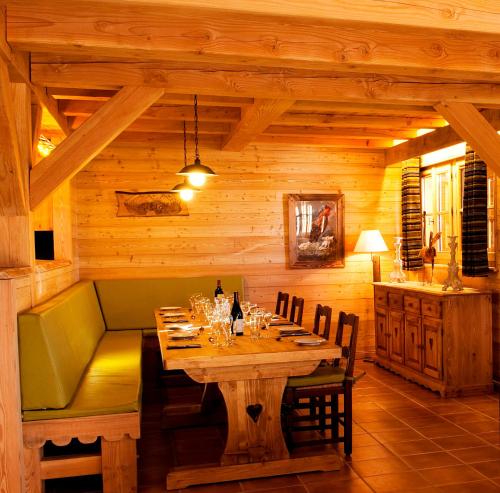 une salle à manger en bois avec une table et des chaises dans l'établissement Madame Vacances Chalet Lièvre Blanc, à L'Alpe-d'Huez