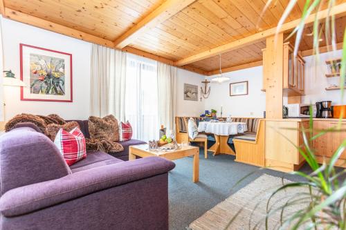 a living room with two purple couches and a table at Haus Alexandra in Werfenweng