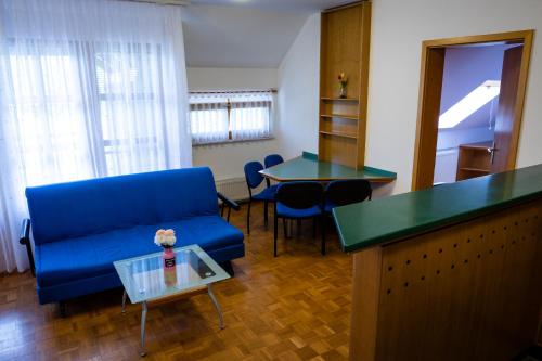 uma sala de estar com um sofá azul e uma mesa em Comfortable apartment in Terme Banovci Spa em Veržej