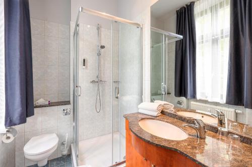 a bathroom with a sink and a shower at SEETELHOTEL Villa Waldesruh in Heringsdorf