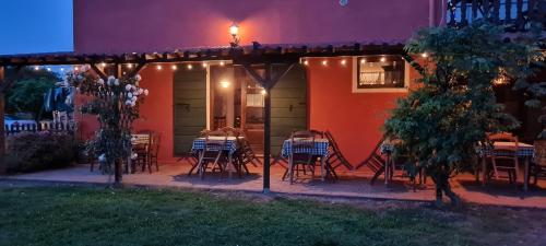 a patio with tables and chairs on a house at night at Hotel Il Casolare in Noghera