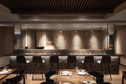 a restaurant with tables and chairs in front of a wall at The Prince Akatoki London in London