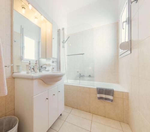 a bathroom with a sink and a tub and a mirror at Gennadi Dreams Holiday Villa in Gennadi