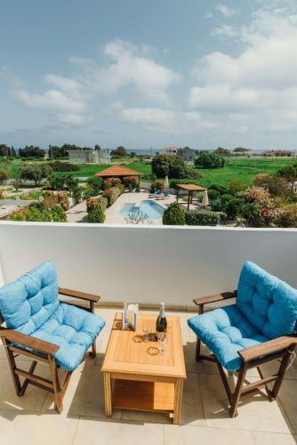 two chairs and a table on a balcony with a pool at Gennadi Dreams Holiday Villa in Gennadi