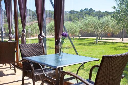 a table with chairs and a vase with flowers on it at S'Hort de Son Caulelles - Adults Only in Marratxí 