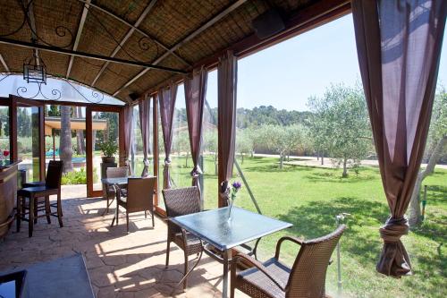 a patio with tables and chairs and a large window at S'Hort de Son Caulelles - Adults Only in Marratxí 
