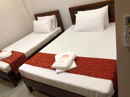 two beds in a hotel room with towels on them at Reddoorz @ Sta Cruz Naga City in Naga
