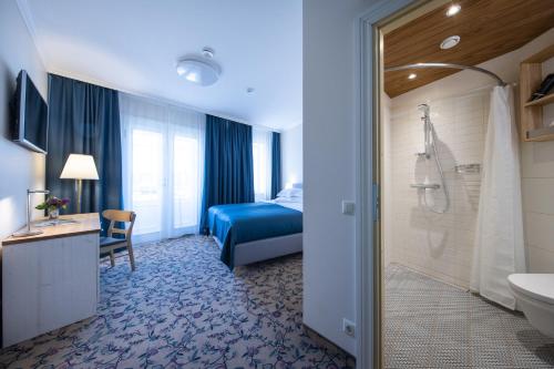 a hotel room with a bathroom with a bed and a shower at Aasa Külalistemaja in Viljandi