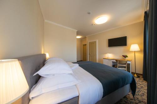 a hotel room with a bed with white pillows at Aasa Külalistemaja in Viljandi