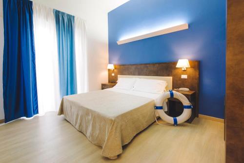 a bedroom with a bed with blue walls and blue curtains at Hotel Giulia in Lido di Camaiore