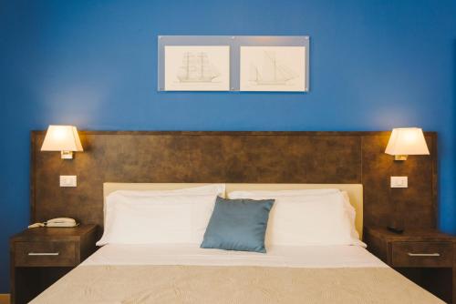 a bedroom with a bed with a blue wall at Hotel Giulia in Lido di Camaiore