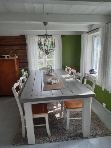Høvåg的住宿－Lillekleiv，一间配备有白色桌椅的用餐室