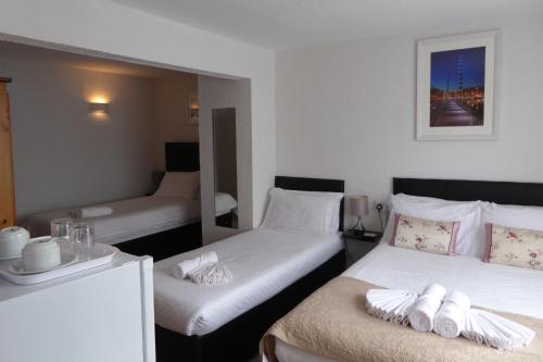 Habitación de hotel con 2 camas y toallas. en Capri Guest House, en Torquay