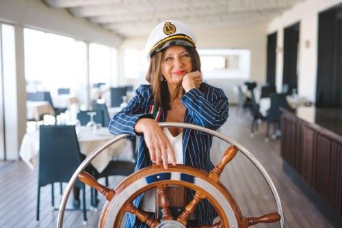 a woman in a sailor uniform standing next to a wheel at Hotel Giulia in Lido di Camaiore