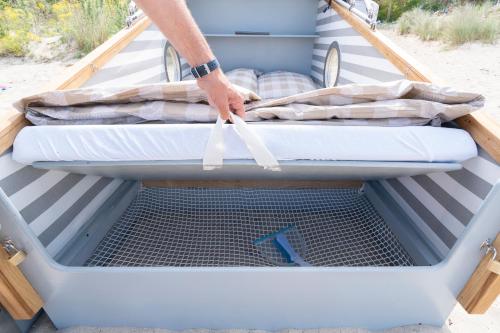 a person is reaching into the open trunk of a truck at Schlafstrandkorb Nr. 4 in Timmendorfer Strand