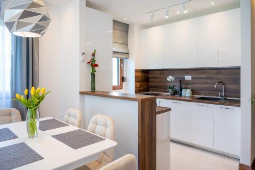 a kitchen with white cabinets and a table with chairs at Montefiori Lux View Apartment in Kotor