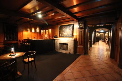 a room with a fireplace and a table and chairs at Hotel Askania 1927 in Bad Wiessee