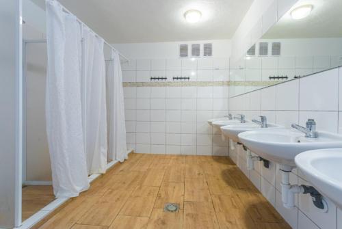 a bathroom with a row of sinks and mirrors at Kemp Andělská laguna Slapy in Nalžovice