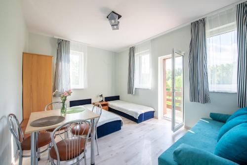 Ośrodek Wypoczynkowy Dolomity في Jedwabno: غرفة معيشة مع أريكة زرقاء وطاولة