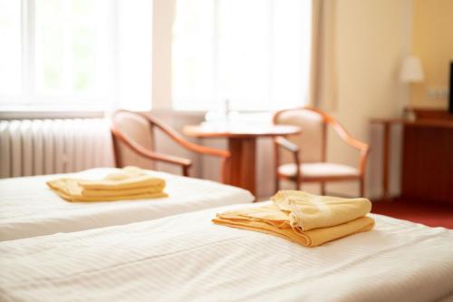 a hotel room with two beds with towels on them at seezeit-resort am Werbellinsee in Joachimsthal