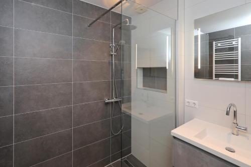 a bathroom with a shower and a sink at Holiday home de Hollandsche Tulp in Noordwijkerhout