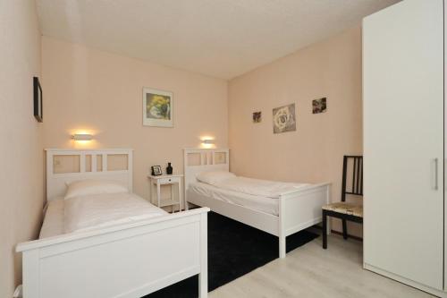 a bedroom with two beds and a mirror at Holiday home de Hollandsche Tulp in Noordwijkerhout