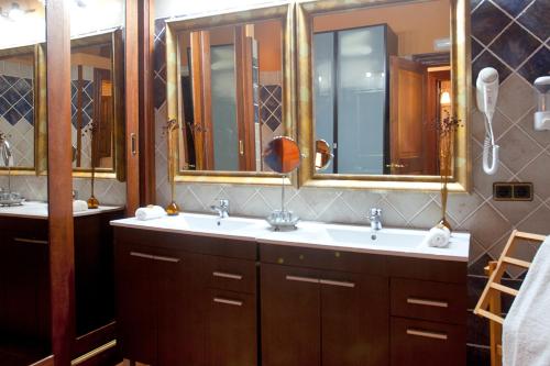 a bathroom with two sinks and two mirrors at S'Hort de Son Caulelles - Adults Only in Marratxí 