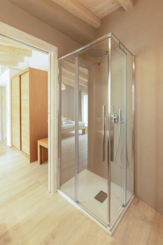 a glass shower in a room with a bedroom at Summer Luxury Apartment Adults Only in Olbia