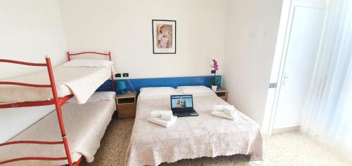 um quarto com 2 beliches e um computador portátil numa mesa em Arix Hotel em Rimini