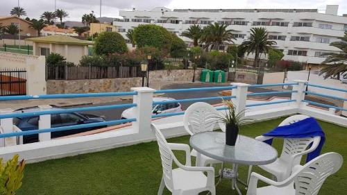 een patio met een tafel en stoelen op een balkon bij Apartamento Vista Lobos in Corralejo