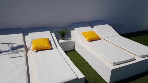 two beds with yellow pillows in a room at Apartamento Talay 1 in Corralejo