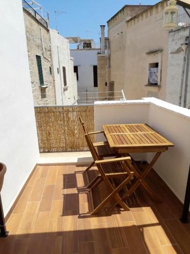 a wooden table and two chairs on a balcony at Charming apartment in Polignano a Mare with terrace. in Polignano a Mare