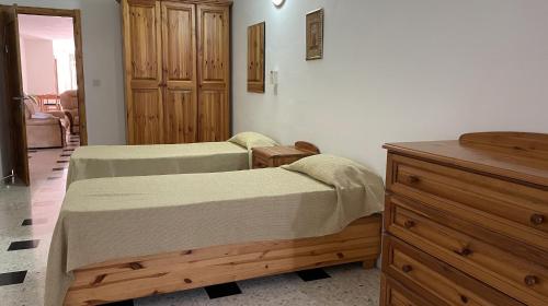1 Schlafzimmer mit 2 Betten und einer Holzkommode in der Unterkunft Apartment with Private Pool in St Paul's Bay