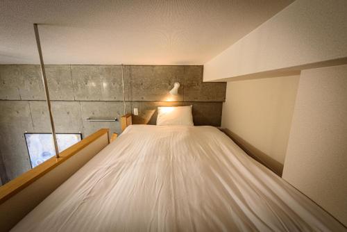 a large bed in a small room with a window at Cocostay The Peace Memorial Park ココステイ平和記念公園 Excellent location overlooking Peace Park! in Hiroshima
