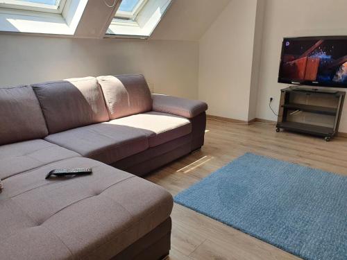 a living room with a couch and a flat screen tv at Pinkóczi Apartmanház in Balatonalmádi