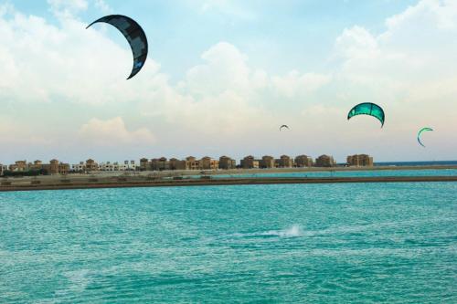 three kites flying over a body of water at Green Sudr Resort in Ras Sedr