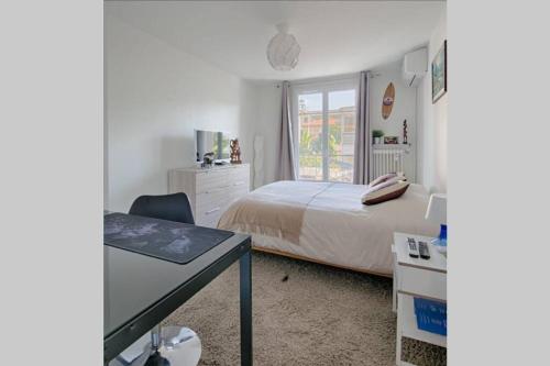 sypialnia z łóżkiem, biurkiem i oknem w obiekcie Charme et Confort pour vos vacances sur Nice w Nicei