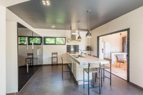 une cuisine avec des armoires blanches et une table et des chaises dans l'établissement Villa Clème, à Grignan