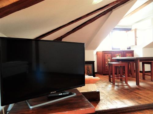 a flat screen tv sitting on a table in a living room at Стаи за гости The Old House in Velingrad