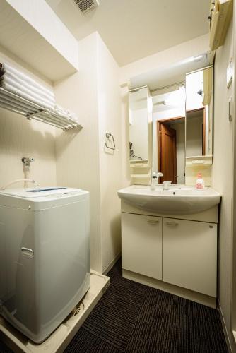 a bathroom with a toilet and a sink and a mirror at Cocostay The Peace Memorial Park ココステイ平和記念公園 Excellent location overlooking Peace Park! in Hiroshima